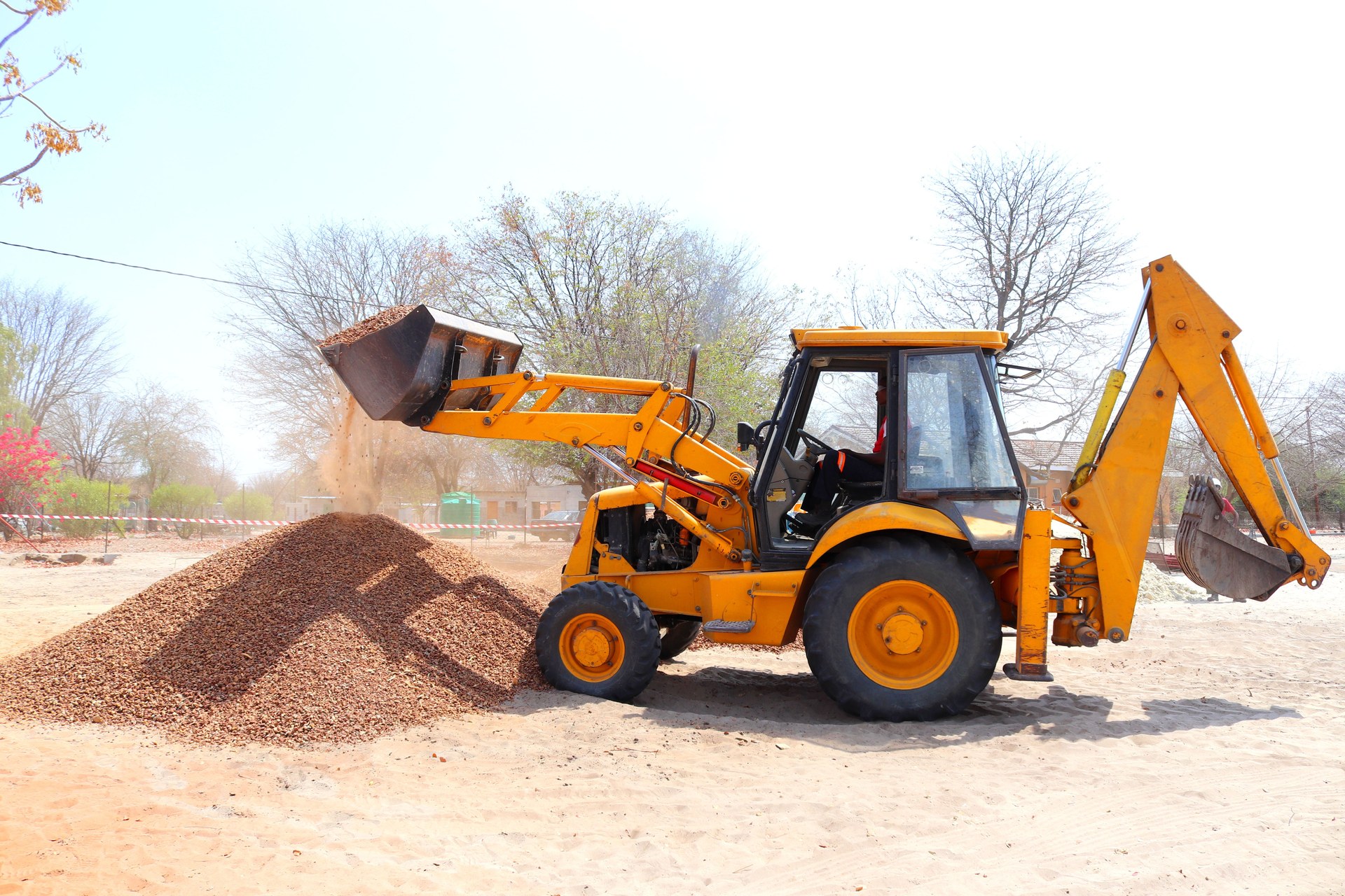 Yellow TLB backhoe loader at a construction site